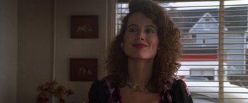 Movie still from “The Accidental Tourist” (1988), directed by Lawrence Kasdan – A person with curly hair wearing a necklace; Close Up shot, Over the shoulder angle