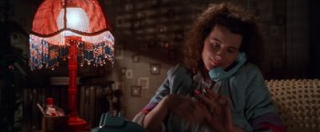 Movie still from “The Accidental Tourist” (1988), directed by Lawrence Kasdan – A young woman is holding a phone in her hand; Close Up shot, High angle