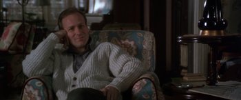 Movie still from “The Accidental Tourist” (1988), directed by Lawrence Kasdan – A man sitting in a chair wearing a sweater; Close Up shot, Over the shoulder angle
