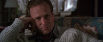 Movie still from “The Accidental Tourist” (1988), directed by Lawrence Kasdan – A person sitting on a couch with his hand on his head; Close Up shot, Low angle