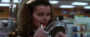 Movie still from “The Accidental Tourist” (1988), directed by Lawrence Kasdan – A woman putting lipstick on in front of a mirror; Close Up shot, Low angle