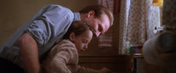 Movie still from “The Accidental Tourist” (1988), directed by Lawrence Kasdan – A man and a little girl looking at something on a computer; Close Up shot, Low angle