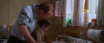 Movie still from “The Accidental Tourist” (1988), directed by Lawrence Kasdan – A man and a child are washing their hands; Medium shot, Low angle
