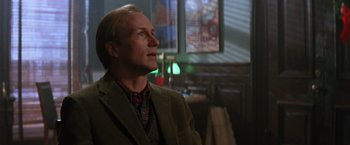 Movie still from “The Accidental Tourist” (1988), directed by Lawrence Kasdan – A man wearing a suit and tie in a room; Close Up shot, Low angle