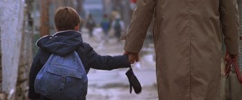 Movie still from “The Accidental Tourist” (1988), directed by Lawrence Kasdan – A young boy holding onto the hand of an older man; Medium shot, Over the shoulder angle