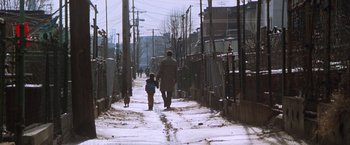 Movie still from “The Accidental Tourist” (1988), directed by Lawrence Kasdan – A man and a child walking down a snowy street; Extreme Wide shot, Low angle