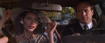 Movie still from “The Accidental Tourist” (1988), directed by Lawrence Kasdan – A woman in a hat in the back of a car; Close Up shot, Over the shoulder angle