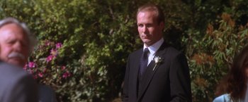Movie still from “The Accidental Tourist” (1988), directed by Lawrence Kasdan – A man in a suit and tie standing in front of a tree; Close Up shot, Low angle