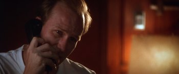 Movie still from “The Accidental Tourist” (1988), directed by Lawrence Kasdan – A person talking on a cell phone; Close Up shot, Low angle