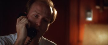 Movie still from “The Accidental Tourist” (1988), directed by Lawrence Kasdan – A person holding a microphone; Close Up shot, Low angle