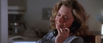 Movie still from “The Accidental Tourist” (1988), directed by Lawrence Kasdan – A woman talking on a phone while sitting down; Close Up shot, Low angle