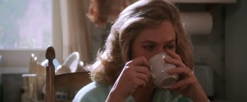 Movie still from “The Accidental Tourist” (1988), directed by Lawrence Kasdan – A woman is drinking a cup of coffee from a mug; Close Up shot, High angle