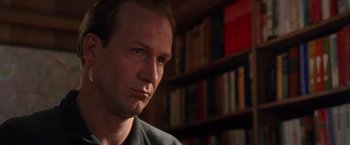 Movie still from “The Accidental Tourist” (1988), directed by Lawrence Kasdan – A man sitting in front of a book shelf; Close Up shot, Low angle
