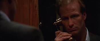 Movie still from “The Accidental Tourist” (1988), directed by Lawrence Kasdan – An older woman holding a pipe in front of her face; Close Up shot, Over the shoulder angle