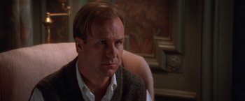 Movie still from “The Accidental Tourist” (1988), directed by Lawrence Kasdan – A person sitting in a chair wearing a vest; Close Up shot, Low angle