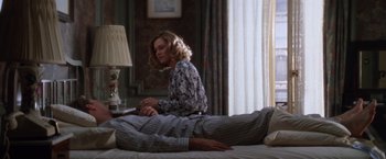 Movie still from “The Accidental Tourist” (1988), directed by Lawrence Kasdan – A woman sitting on a bed next to a man; Medium shot, High angle