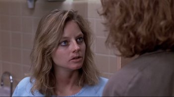 Movie still from “The Accused” (1988), directed by Jonathan Kaplan – A woman looking into a mirror in front of a wall; Close Up shot, Over the shoulder angle