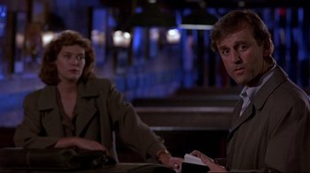 Movie still from “The Accused” (1988), directed by Jonathan Kaplan – A man and a woman sitting at a table in front of each other; Medium shot, Over the shoulder angle