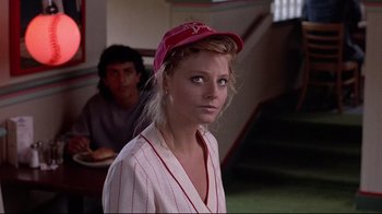 Movie still from “The Accused” (1988), directed by Jonathan Kaplan – A woman wearing a baseball cap in front of a man; Close Up shot, Over the shoulder angle