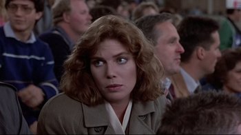 Movie still from “The Accused” (1988), directed by Jonathan Kaplan – A person sitting in front of a crowd; Close Up shot, Over the shoulder angle