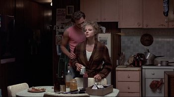 Movie still from “The Accused” (1988), directed by Jonathan Kaplan – A man and a woman standing in a kitchen; Medium shot, Over the shoulder angle