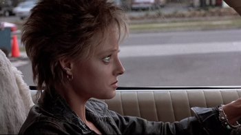 Movie still from “The Accused” (1988), directed by Jonathan Kaplan – A woman sitting in the back seat of a car looking out the window; Close Up shot, Over the shoulder angle