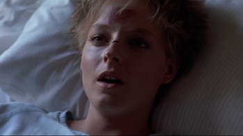 Movie still from “The Accused” (1988), directed by Jonathan Kaplan – A woman with a bruise on her face laying in bed; Close Up shot, Overhead angle