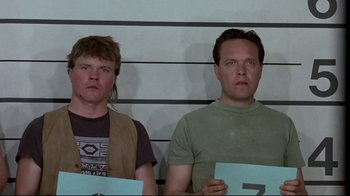 Movie still from “The Accused” (1988), directed by Jonathan Kaplan – Two men are standing in front of a wall; Medium shot, Low angle