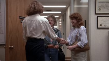 Movie still from “The Accused” (1988), directed by Jonathan Kaplan – Three women are shaking hands in an office hallway; Medium shot, Over the shoulder angle