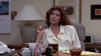 Movie still from “The Accused” (1988), directed by Jonathan Kaplan – A woman sitting at a table with a pen in her hand; Close Up shot, Over the shoulder angle