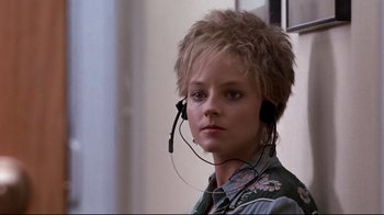 Movie still from “The Accused” (1988), directed by Jonathan Kaplan – A woman with a headset on looking at the camera; Close Up shot, Over the shoulder angle