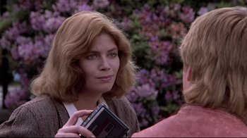 Movie still from “The Accused” (1988), directed by Jonathan Kaplan – A woman holding a book while standing next to another woman; Close Up shot, Over the shoulder angle