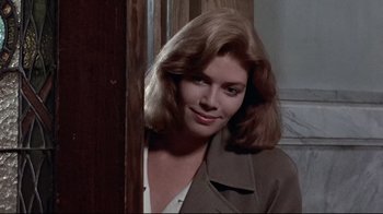 Movie still from “The Accused” (1988), directed by Jonathan Kaplan – A woman in a trench coat leaning against a wall; Close Up shot, Over the shoulder angle