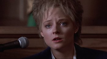 Movie still from “The Accused” (1988), directed by Jonathan Kaplan – A person with a microphone in a room; Close Up shot, Low angle