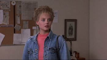 Movie still from “The Accused” (1988), directed by Jonathan Kaplan – A woman in a pink shirt and a jean jacket; Close Up shot, Over the shoulder angle