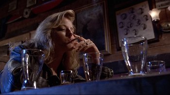 Movie still from “The Accused” (1988), directed by Jonathan Kaplan – A woman sitting at a table smoking a cigarette; Close Up shot, Low angle