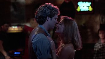 Movie still from “The Accused” (1988), directed by Jonathan Kaplan – A man and a woman are kissing in the dark; Close Up shot, Over the shoulder angle