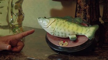 Movie still from “The Act of Killing” (2012), directed by Joshua Oppenheimer – A fish on top of a scale on top of a counter; Extreme Close Up shot, High angle