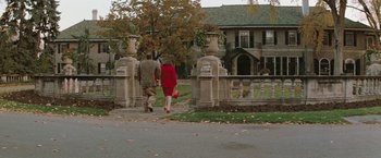 Movie still from “The Adjuster” (1991), directed by Atom Egoyan – A man and a woman walking down a sidewalk; Wide shot, High angle