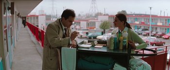 Movie still from “The Adjuster” (1991), directed by Atom Egoyan – A man and a woman sitting at a table; Medium shot, Low angle