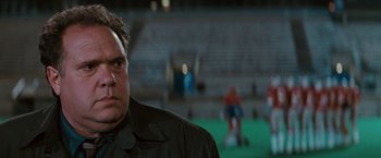 Movie still from “The Adjuster” (1991), directed by Atom Egoyan – A person wearing a black jacket; Close Up shot, Low angle