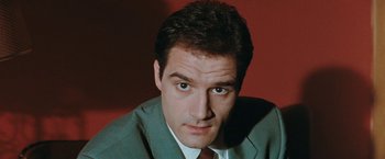 Movie still from “The Adjuster” (1991), directed by Atom Egoyan – A person wearing a suit and tie; Close Up shot, Low angle