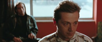 Movie still from “The Adjuster” (1991), directed by Atom Egoyan – A person wearing a shirt; Close Up shot, Over the shoulder angle