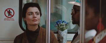 Movie still from “The Adjuster” (1991), directed by Atom Egoyan – A woman sitting next to a man on a bus; Close Up shot, Over the shoulder angle