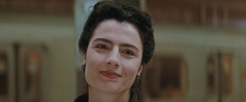 Movie still from “The Adjuster” (1991), directed by Atom Egoyan – A person smiling for the camera; Close Up shot, Over the shoulder angle