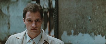Movie still from “The Adjuster” (1991), directed by Atom Egoyan – A person wearing a shirt and tie; Close Up shot, Low angle