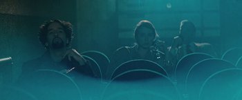 Movie still from “The Adjuster” (1991), directed by Atom Egoyan – Two people are sitting in a dark room; Medium shot, Low angle