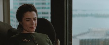 Movie still from “The Adjuster” (1991), directed by Atom Egoyan – A woman sitting in a chair in front of a window; Close Up shot, Over the shoulder angle