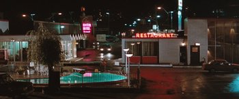 Movie still from “The Adjuster” (1991), directed by Atom Egoyan – A view of a restaurant from across the street; Extreme Wide shot, High angle