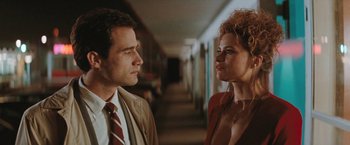 Movie still from “The Adjuster” (1991), directed by Atom Egoyan – A man and a woman standing next to each other in a hallway; Close Up shot, Low angle